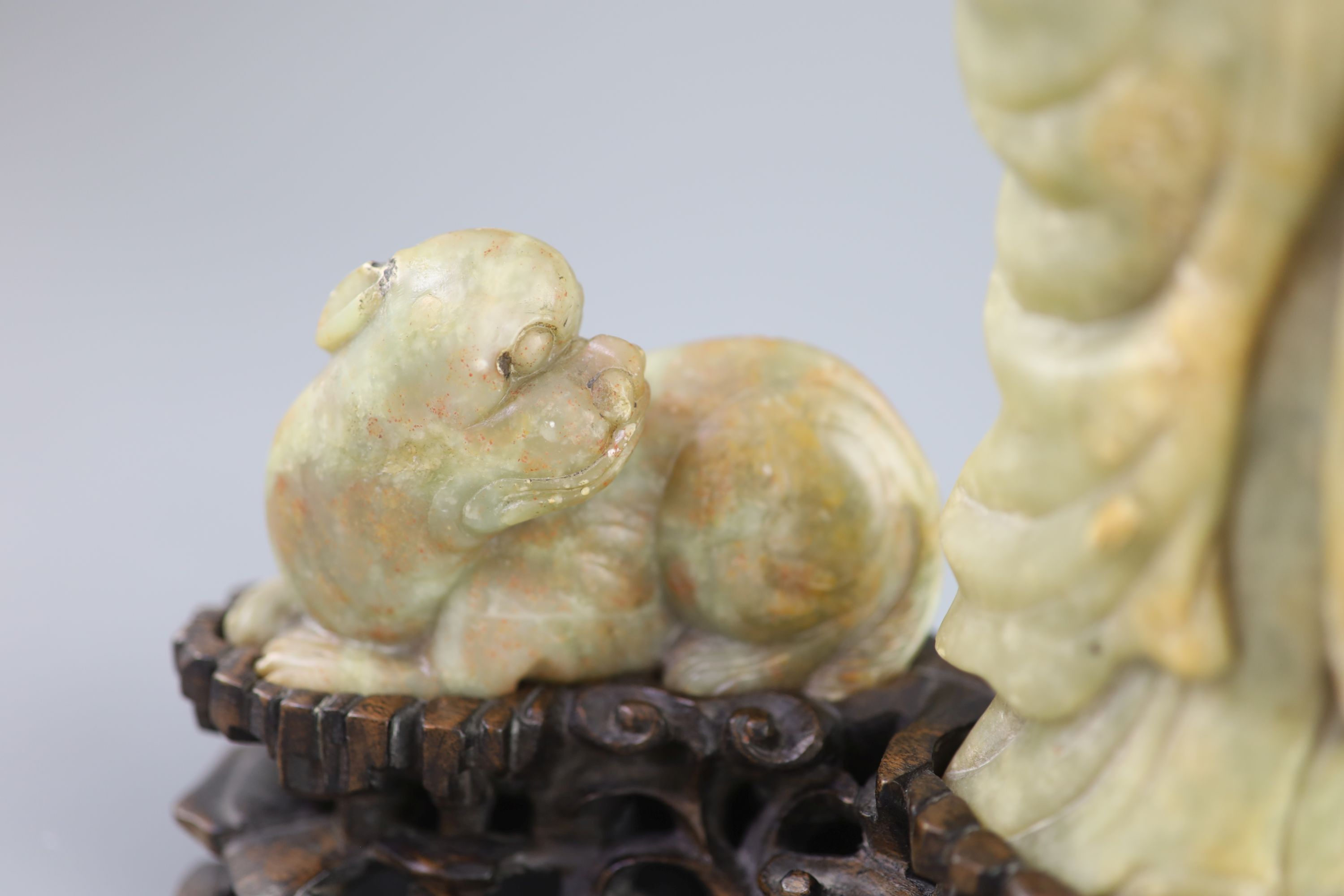 A Chinese soapstone group of a luohan and a lion dog, possibly 17th/18th century, 22.5 cm height including card wood stand